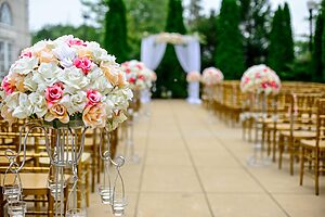 Outdoor wedding ceremony setup with floral aisle arrangements and decorated arch ready for the ceremony.