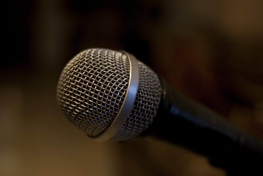 close up of a microphone with a blurred brown background.