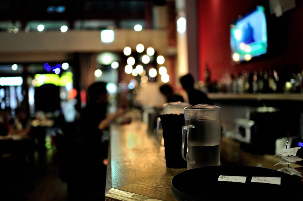 a pub with drink on the bar island and t in the background